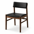 Chaise contemporaine en bois brun, assise et dossier rembourrés noirs effet cuir, 54 × 56 × 79 cm